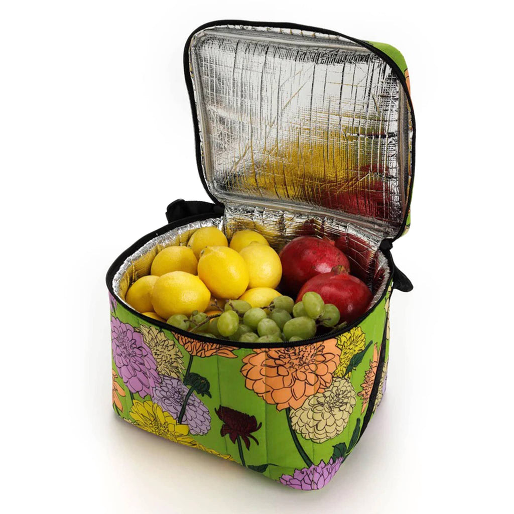 Baggu Insulated Puffy Cooler Bag with Dahlia print on a green backdrop with black zipper, shoulder strap and handle, front angle view, lid open showing lemons, grapes and pomegranates inside.