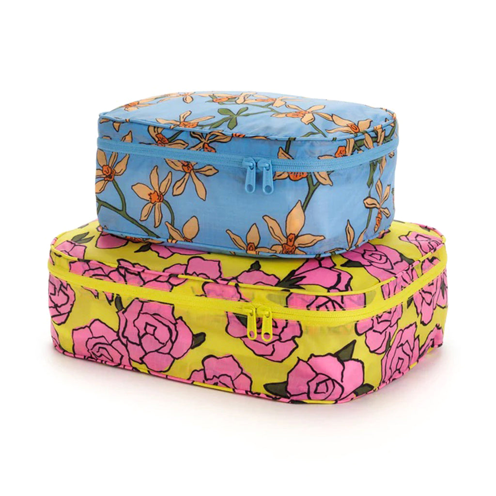 Baggu reusable recycled ripstop nylon packing cube set of 2, large is in rose print and the small cube has the orchid print, stuffed and stacked.