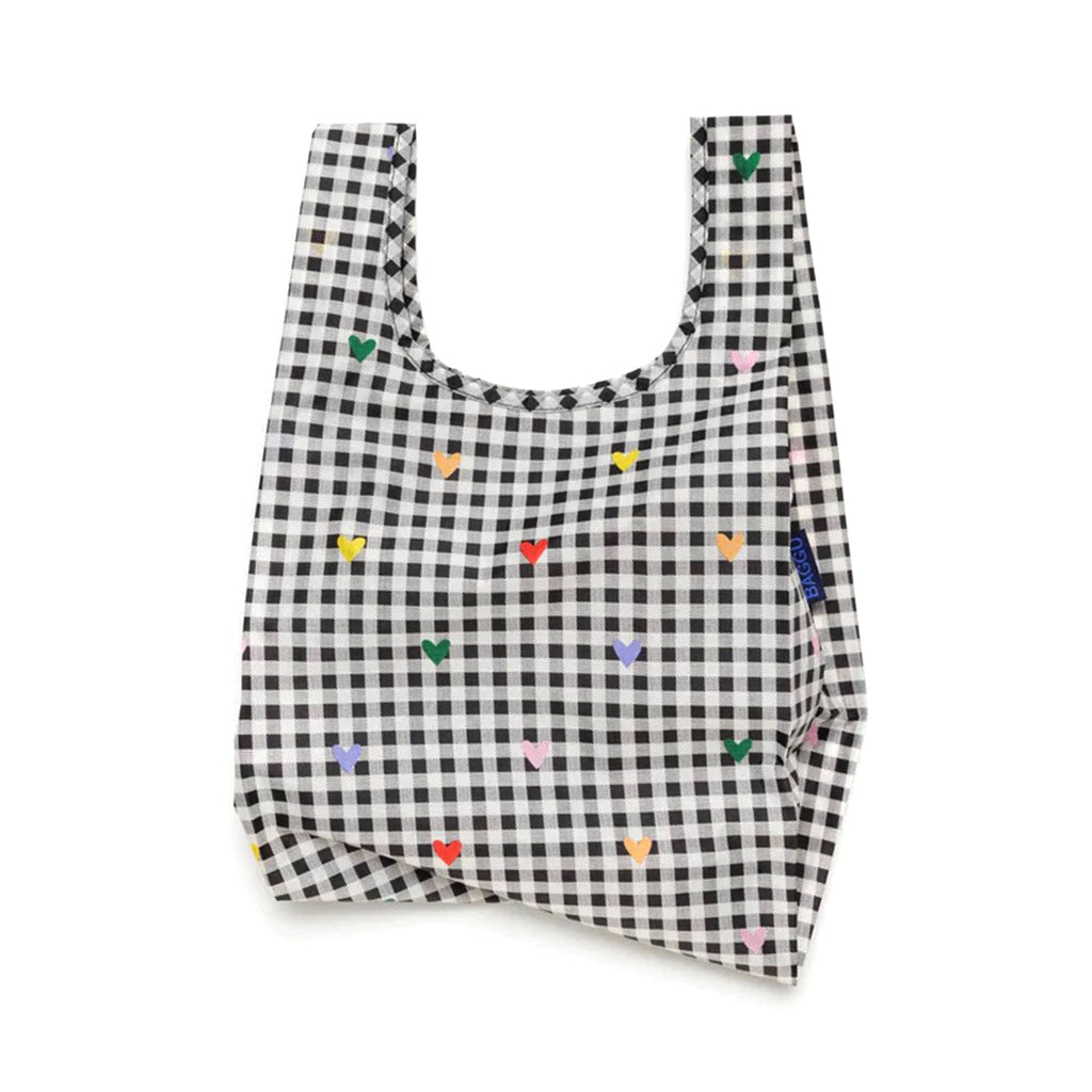 Baggu baby size eco-friendly recycled ripstop nylon reusable tote bag with tiny colorful hearts on a white and black gingham backdrop, unfolded.