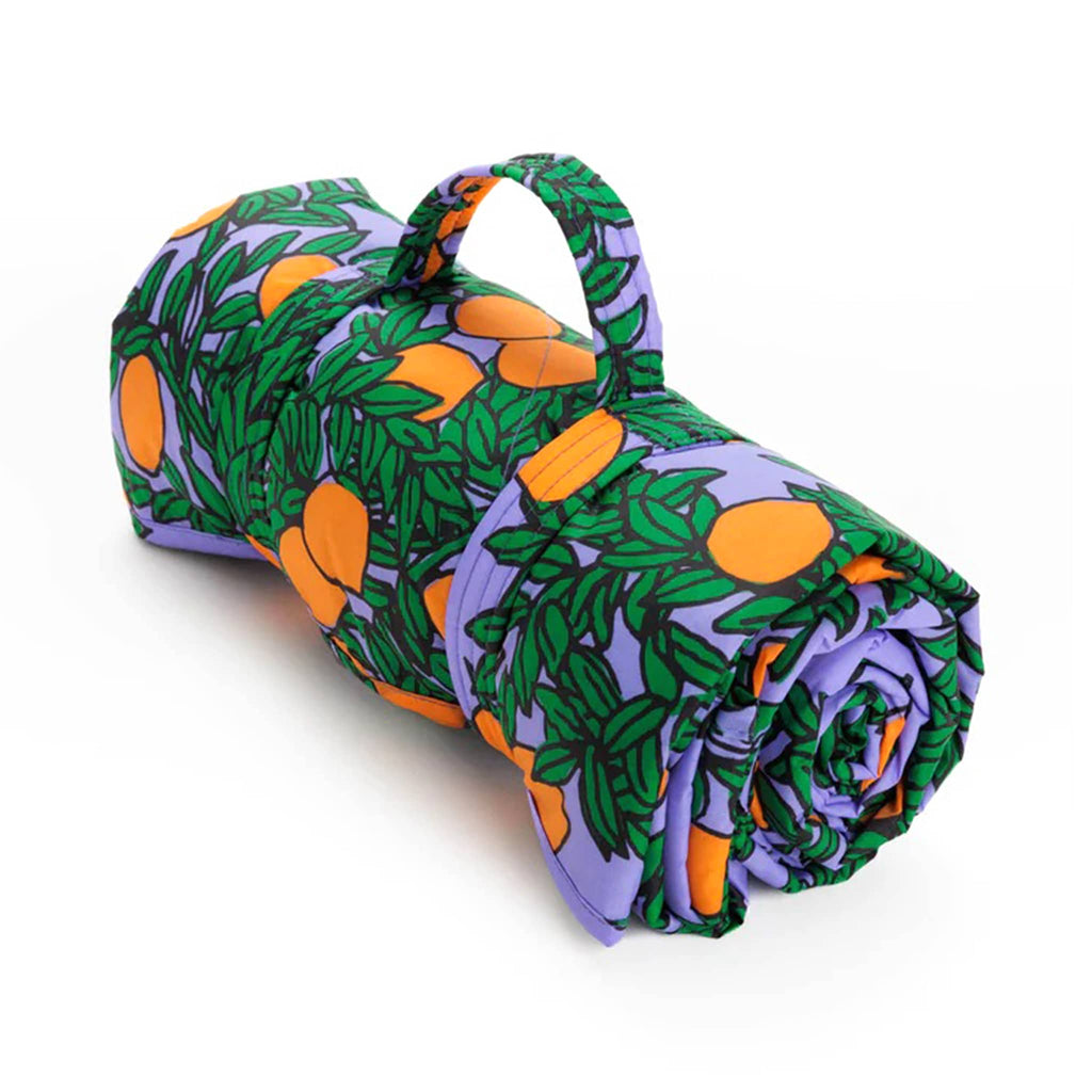 Baggu orange tree periwinkle puffy recycled ripstop nylon and polyester picnic blanket, rolled up with strap.