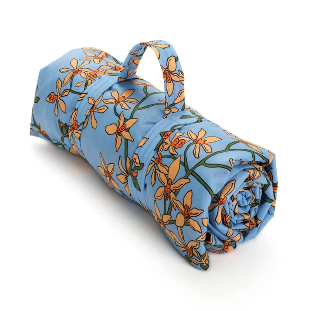 Baggu orchid puffy recycled ripstop nylon and polyester picnic blanket, rolled up with strap.