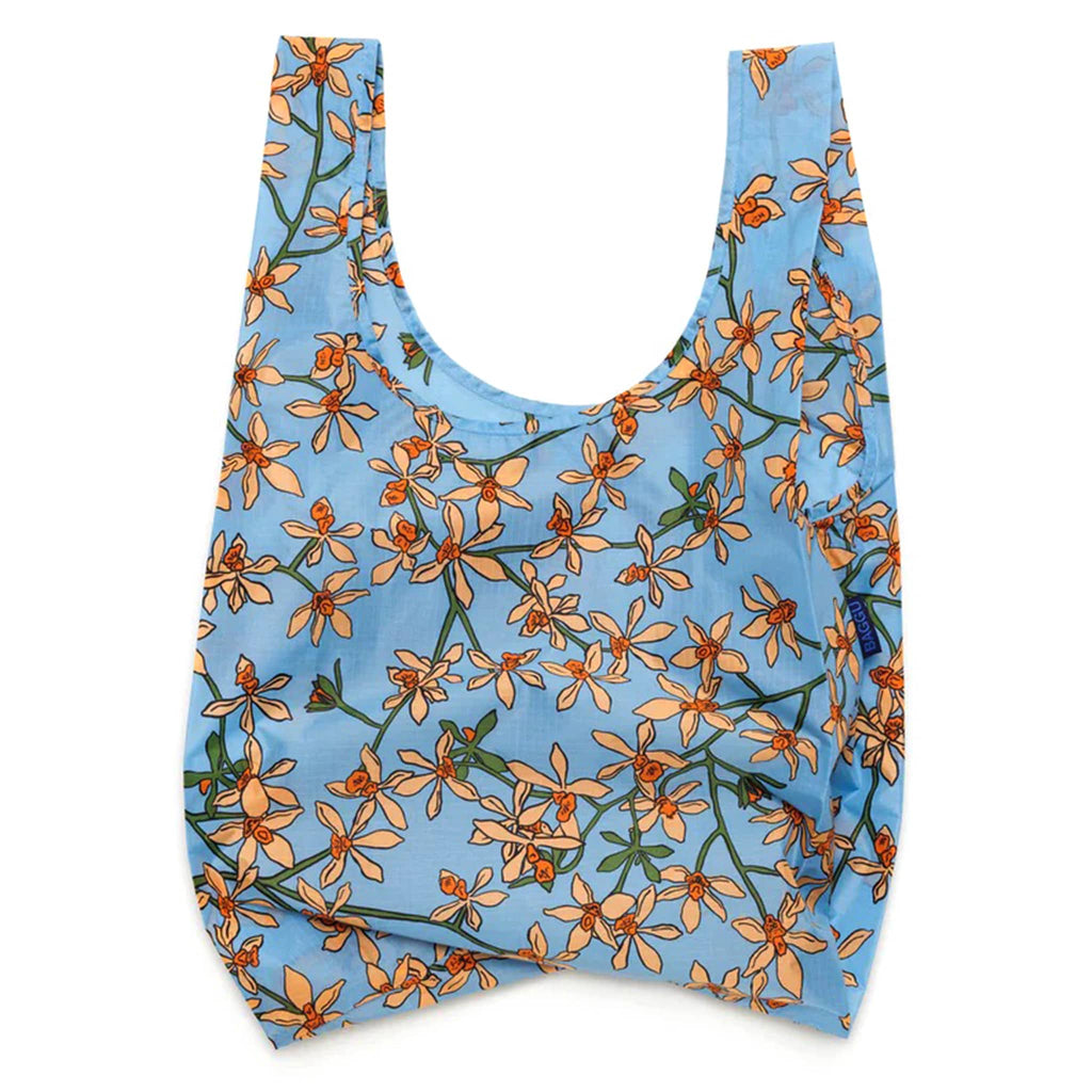 Baggu standard size eco-friendly recycled ripstop nylon reusable tote bag with an orange orchid print on a blue backdrop, unfolded.