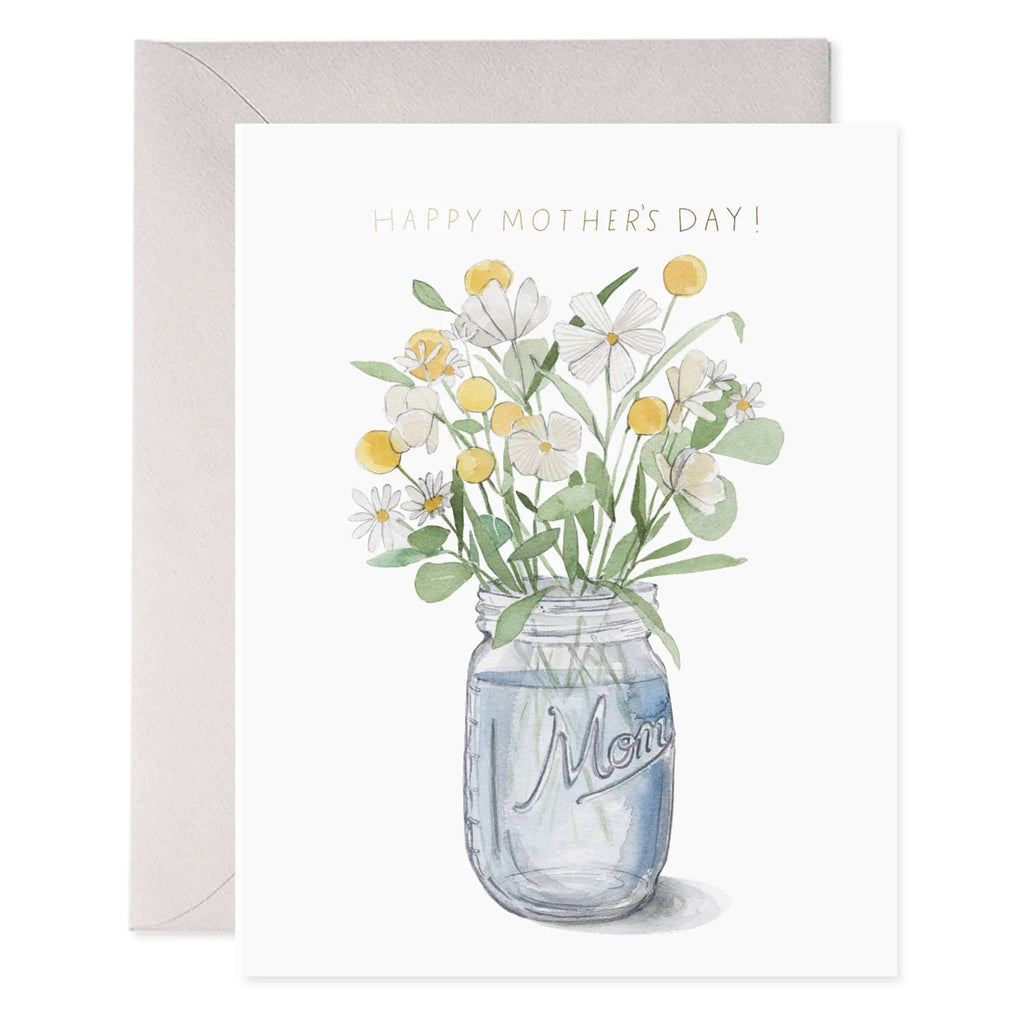 E. Frances Paper Mason Jar Mom greeting card with yellow and white flowers in a mason jar illustration and "happy mother's day" in gold foil, front of card shown with a soft gray envelope.