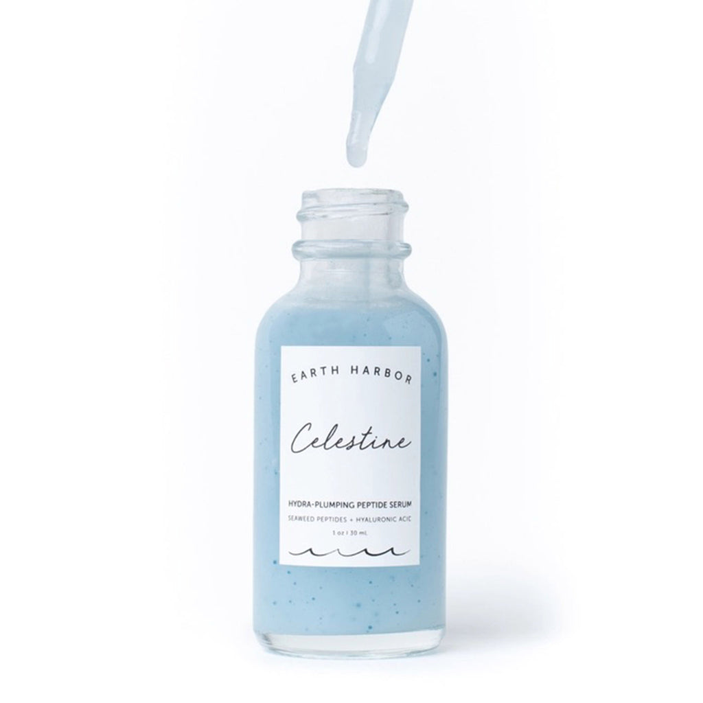 Earth Harbor Celestine Hydra-Plumping Peptide Serum in glass bottle with eyedropper dripping light blue serum into bottle.