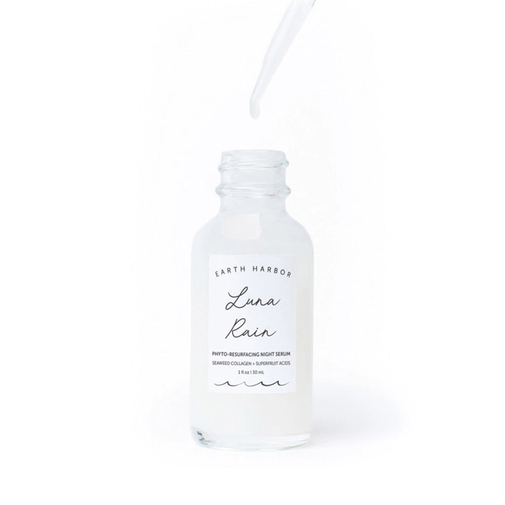 Earth Harbor Luna Rain Phyto-Resurfacing Night Serum in glass bottle with eyedropper dripping serum into bottle.