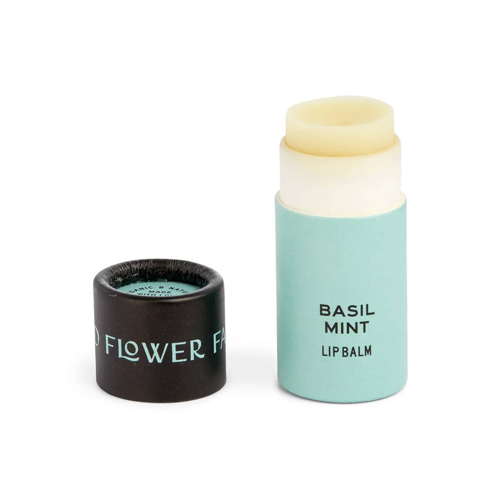 Good Flower Farm Basil Mint scented lip balm in aqua blue paper tube packaging with lid off.