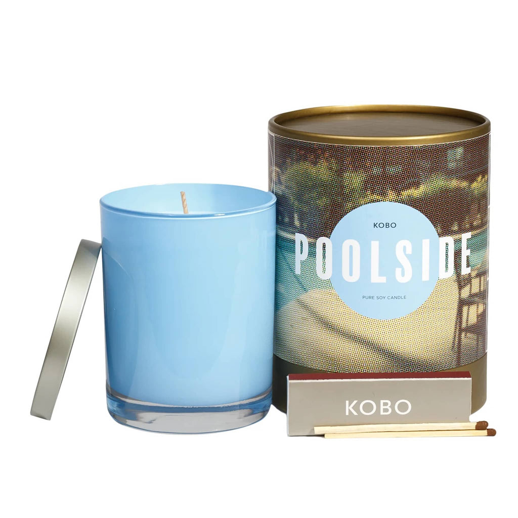KOBO 11 ounce Poolside candle, part of the Road Trip Collection, in glossy blue glass vessel with metal lid next to illustrated canister packaging with a pack of wooden matches.