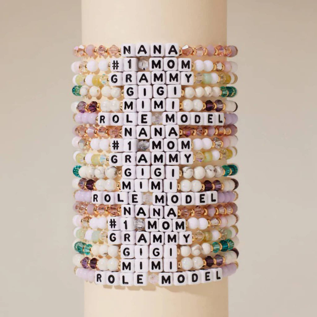 Little Words Project Grammy beaded elastic bracelet in matcha bead design;  aqua, green and white beads with iridescent faux crystal beads, gold spacer beads and letter beads. Shown stacked with other similar bracelets.