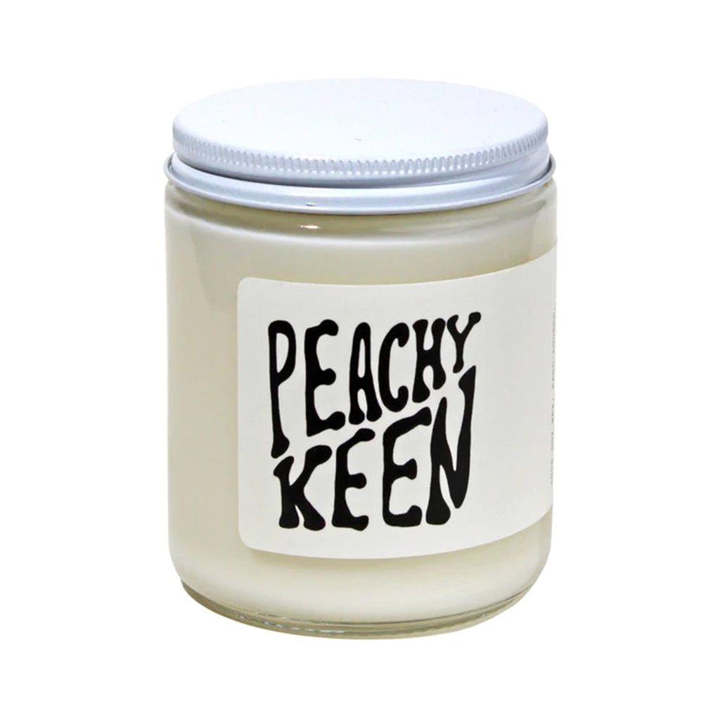 MOCO Candles Peachy Keen scented soy wax candle in clear glass jar with white metal lid and white label with black lettering.