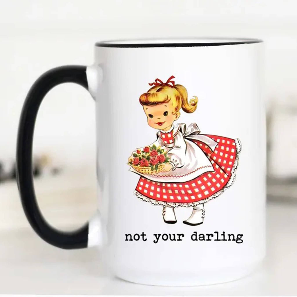 Mugsby white ceramic mug with black handle and rim with a vintage-inspired illustration of a girl with a basket of flowers and "not your darling" in black lettering.