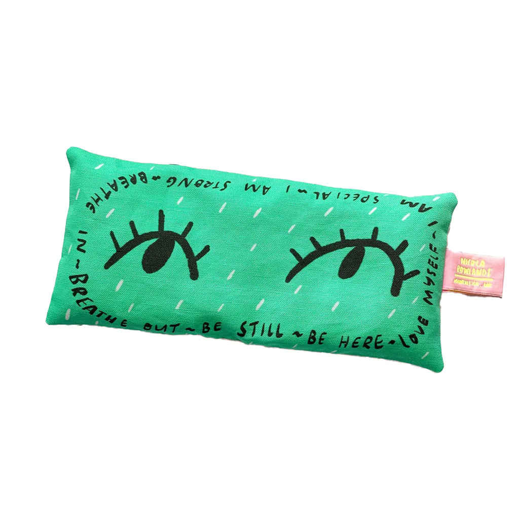 Nicola Rowlands lavender scented weighted eye pillow in green with eye illustrations and positive affirmations in black lettering all around the edges.