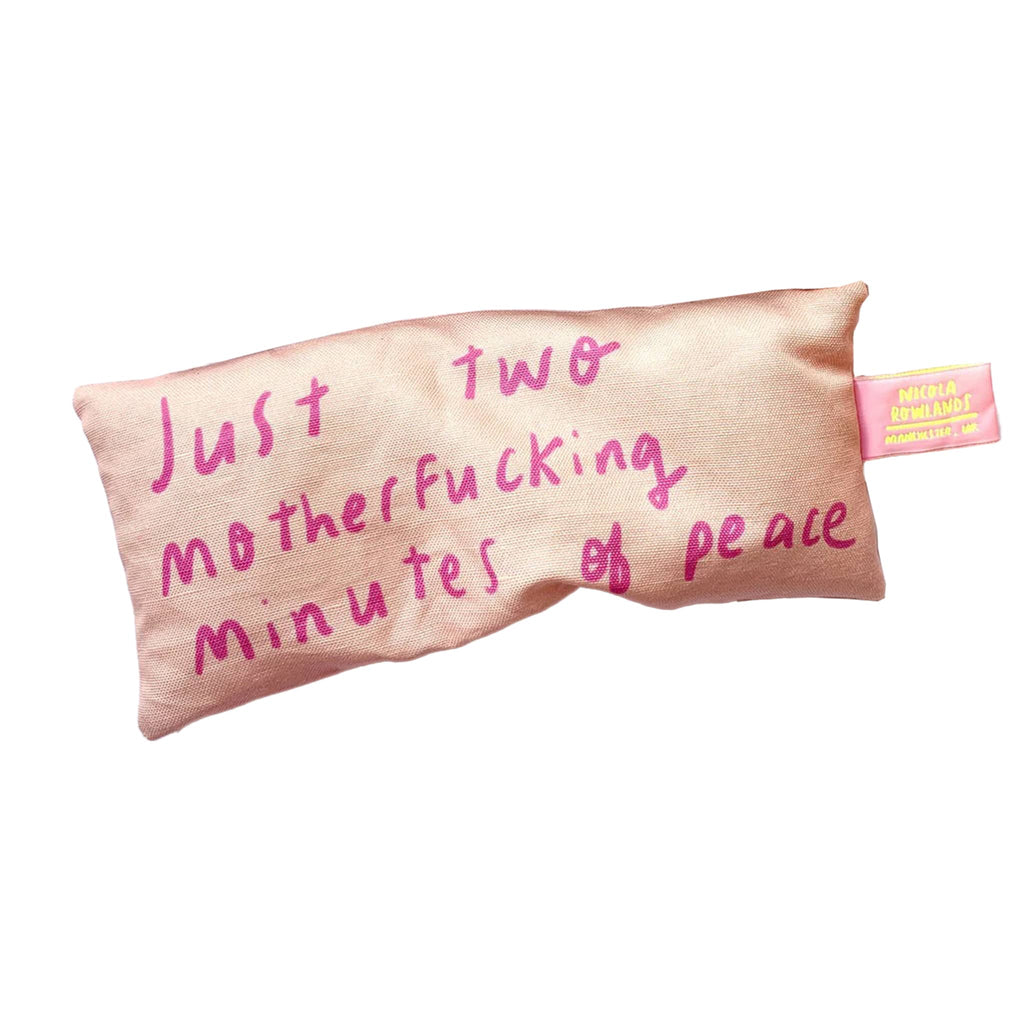 Nicola Rowlands lavender scented weighted eye pillow in pink with "just two motherfucking minutes of peace" in fuchsia lettering.