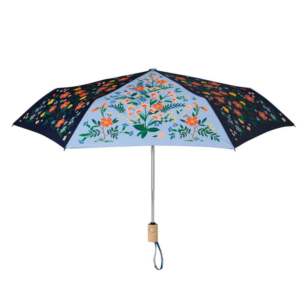 rifle paper company umbrella with wildwood floral print on sky blue and navy blue colorblock panels, open, side view.
