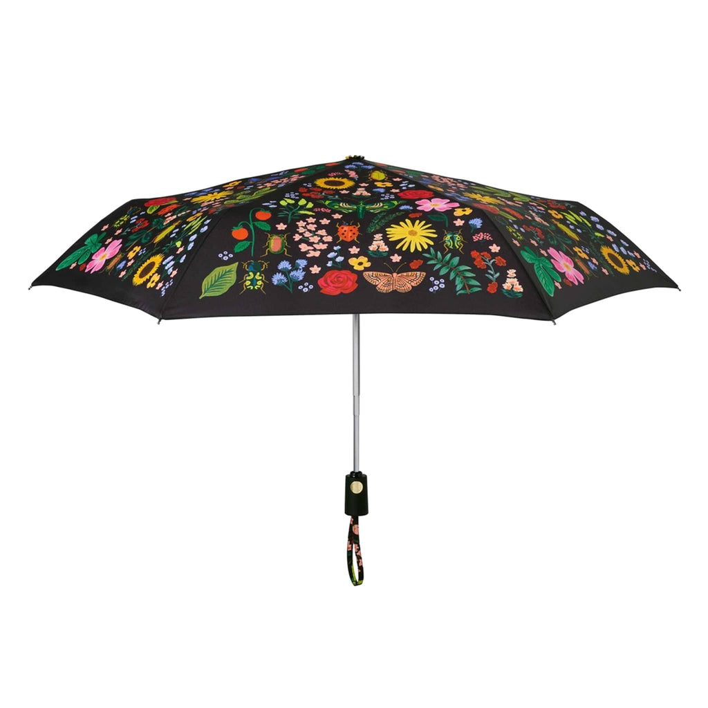 rifle paper company umbrella with curio floral and bug print on black panels, open, side view.