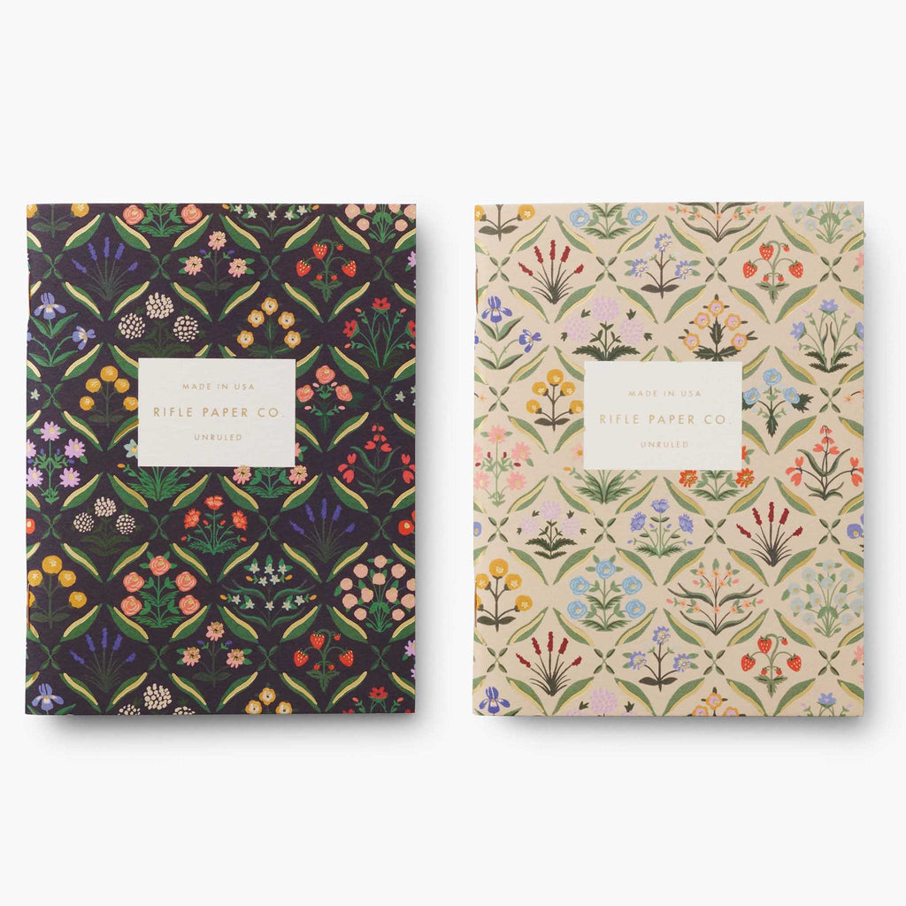 Rifle Paper Co. Estee pocket notebook set of 2 with floral print on a black backdrop and on an off-white backdrop.
