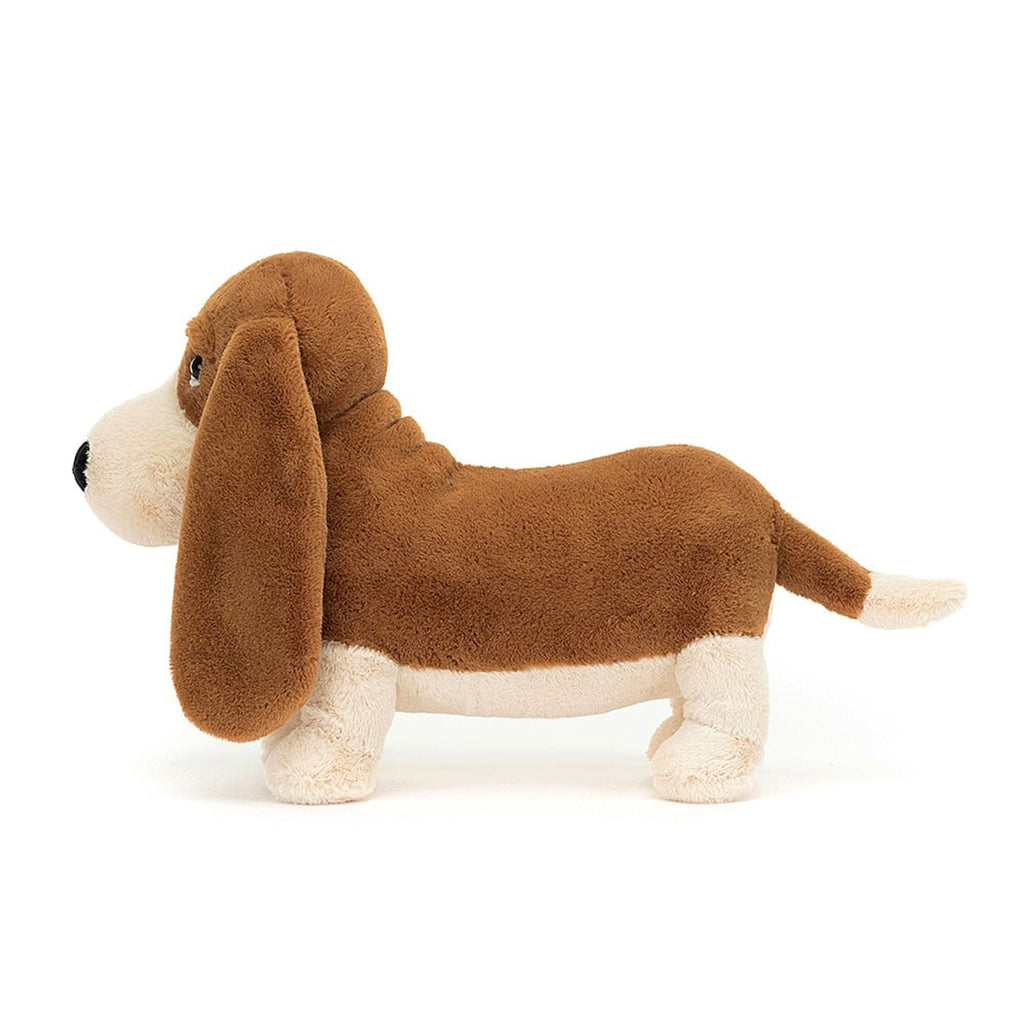 Jellycat Randall Basset Hound plush toy with brown and cream fur, long ears, black bead eyes and black nose in standing position, side view.