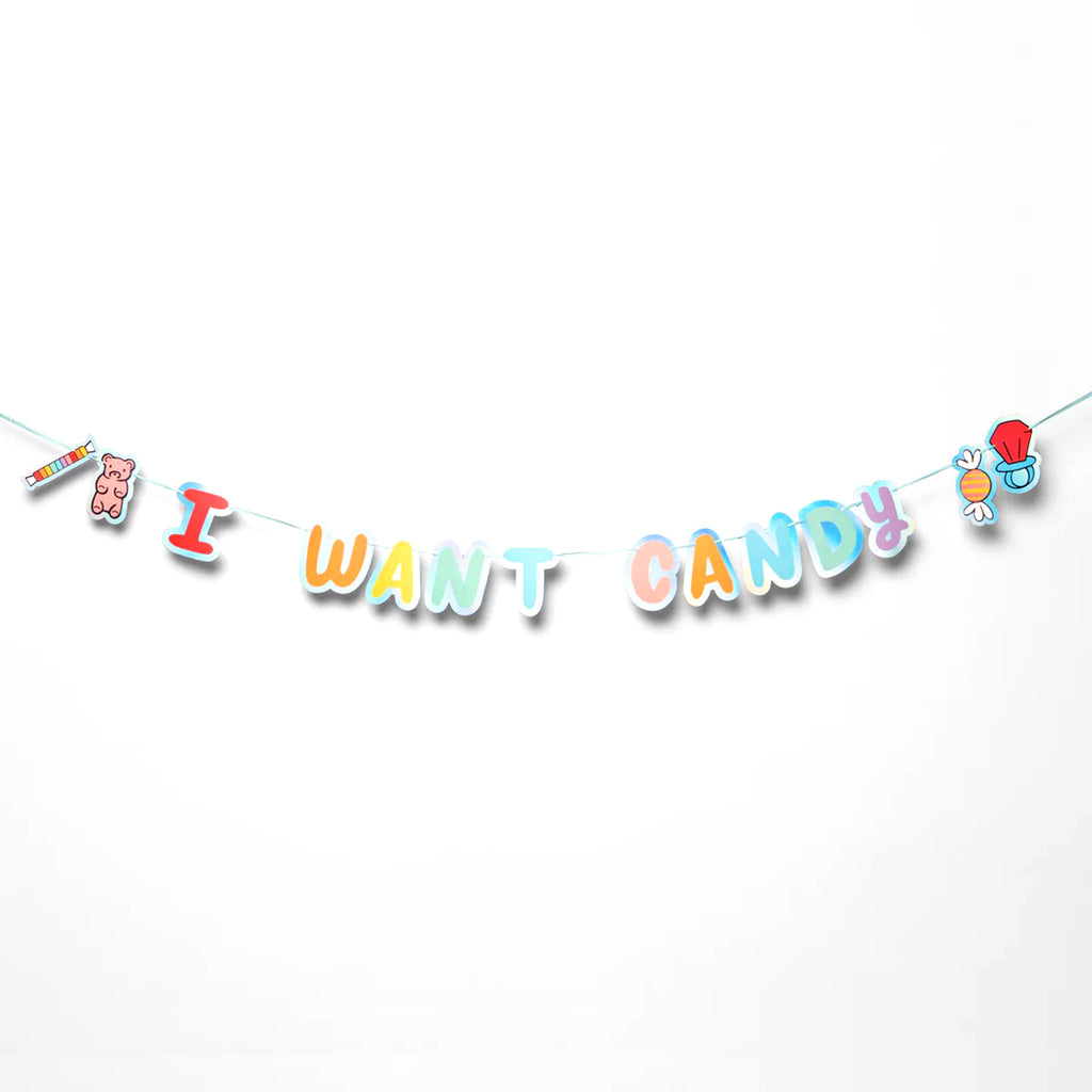 I Want Candy Party Banner with colorful letters outlined in iridescent foil, strung on a light blue ribbon.