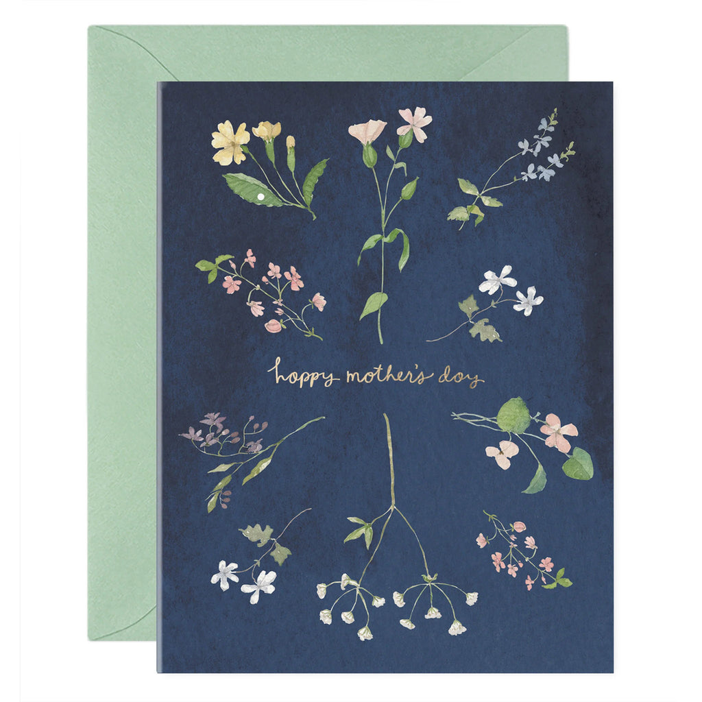 E. Frances Paper mother's day card with wildflower illustrations on a dark blue backdrop and "happy mother's day" in gold foil lettering. Shown with a sage green envelope.