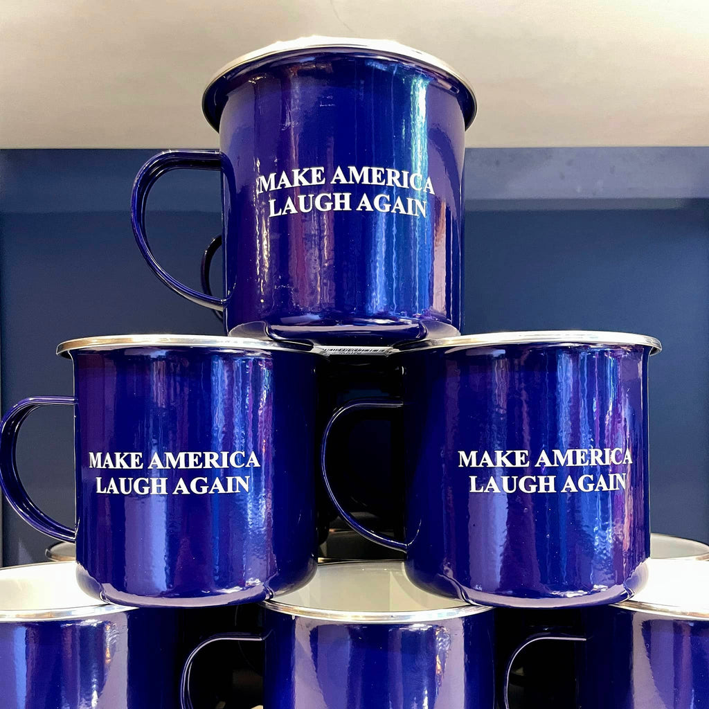 Navy blue stainless steel camp mug with D-shaped handle and "Make America Laugh Again" in white lettering, in a stack.