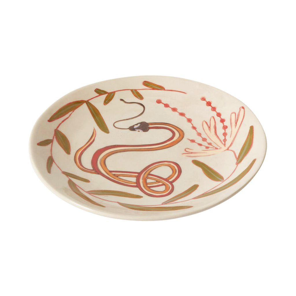 Accent Decor Parable Snake Ceramic Plate with a hand-painted red, orange and green snake and leaf design on a cream backdrop.