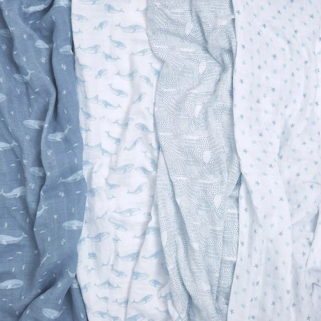 Aden + Anais Oceanic set of 4 organic cotton muslin baby swaddle blankets, prints have whales, waves and starfish in blue and white.