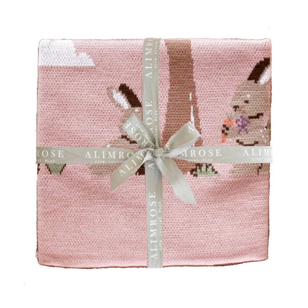 Alimrose Bunnies Day Out cotton baby blanket folded up and tied with a logo ribbon.