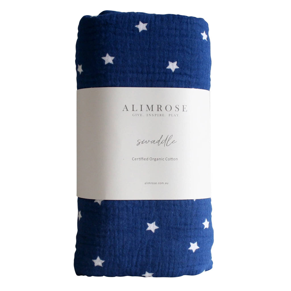 Alimrose Starry Night Navy organic cotton muslin baby swaddle, rolled up with bellyband packaging.