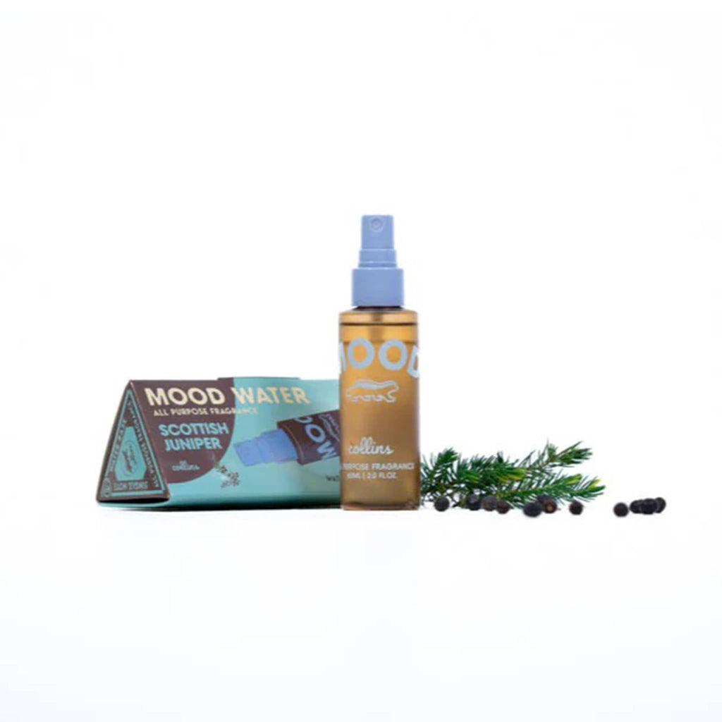 Mood water spray bottle with packaging and juniper berries on a white background.