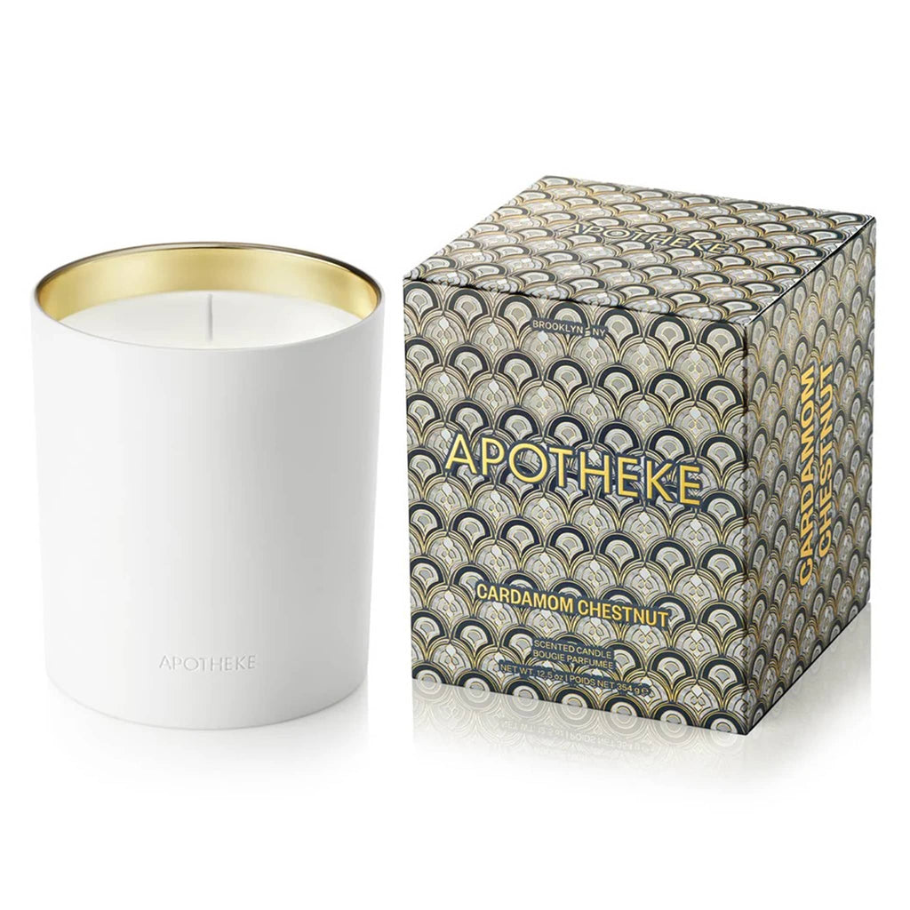 Apotheke Cardamom Chestnut 12.5 ounce scented candle in white ceramic vessel with gold interior, shown beside navy and gray art deco printed box.