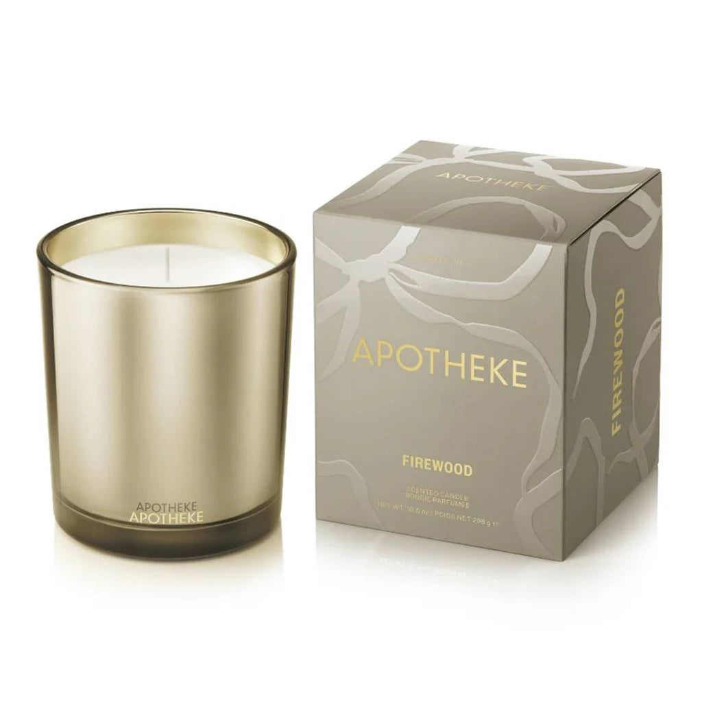 Apotheke Firewood candle with beige metallic finish and matching packaging on a white background.