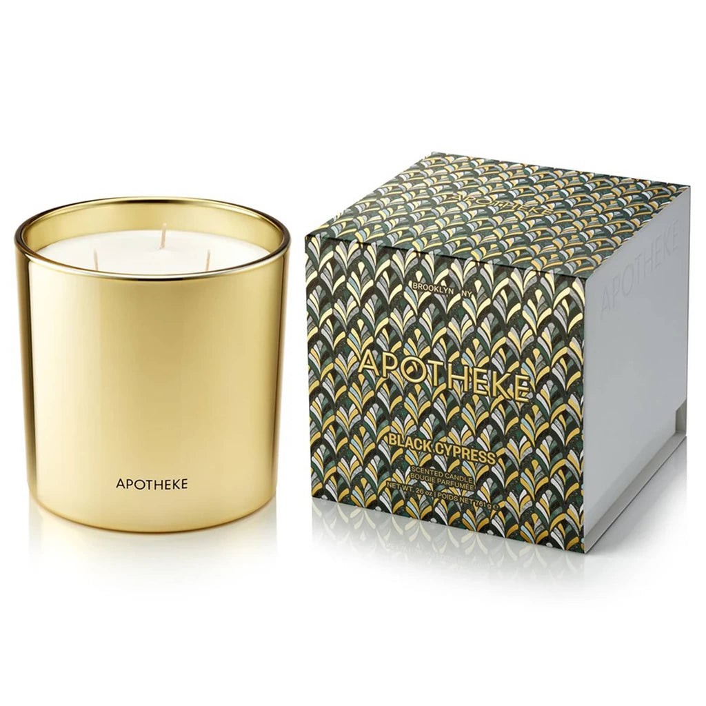 Apotheke Black Cypress 26 ounce 3-wick scented candle in gold vessel, shown beside a green and gold art deco printed slipcase box.