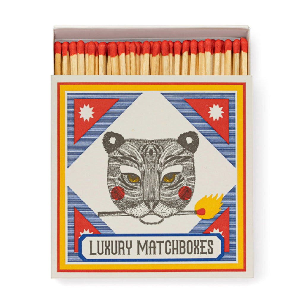 Archivist Gallery Ariane Tiger square match box with red, blue, yellow and black tiger illustration, slid open slightly to see red-tipped wood 4 inch matches inside.