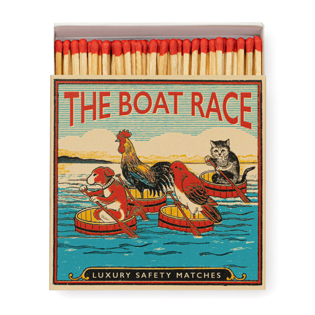 Archivist Gallery The Boat Race square match box with an illustration of a dog, pigeon, rooster and cat in barrels with oars on a river, slid open slightly to see red-tipped wood 4 inch matches inside.