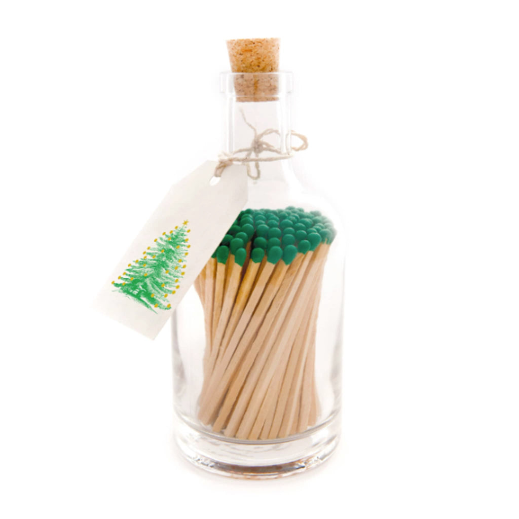 Archivist Gallery glass bottle with green-tipped wood safety matches and a tag with a Christmas tree adorned with gold foil balls, front view.