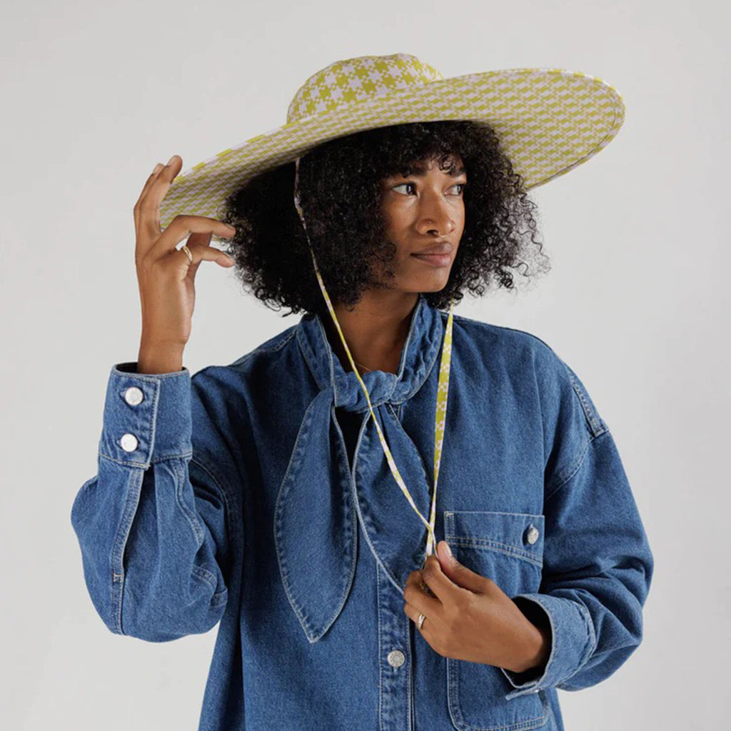 Baggu pink and pistachio green Pixel Gingham print cotton packable sun hat on model to show fit.