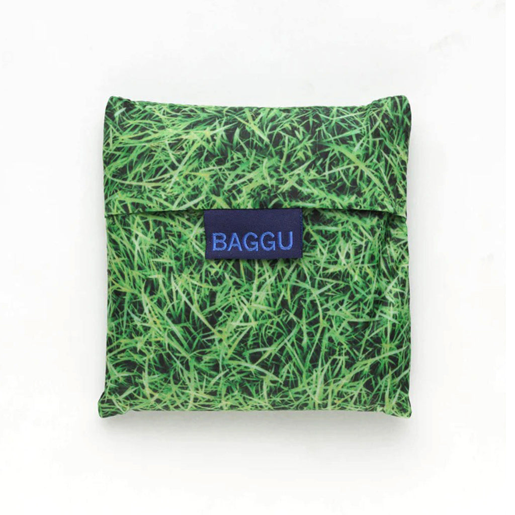 Baggu standard size eco-friendly-recycled ripstop nylon reusable tote bag with green grass pattern, in matching pouch.