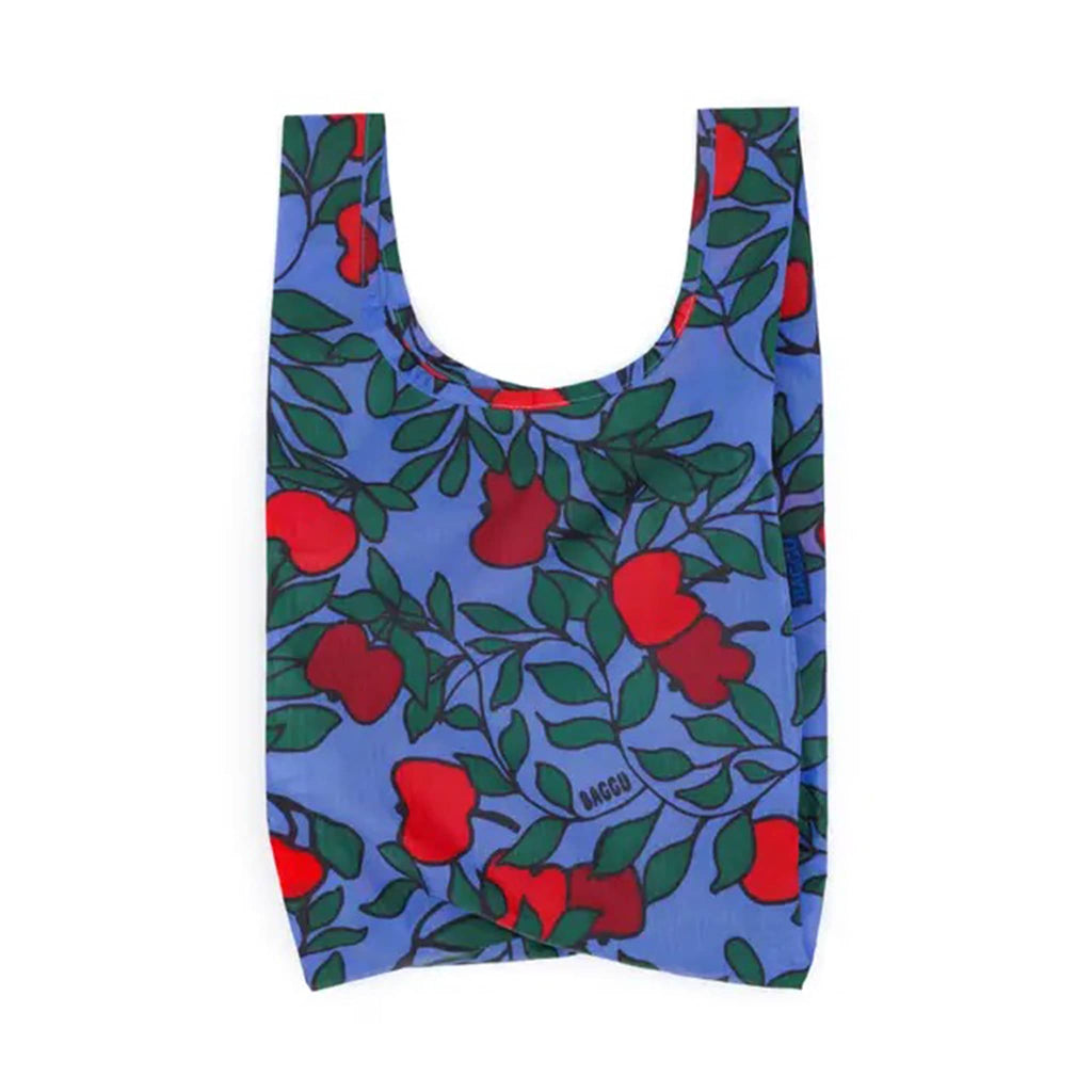 Reusable shopping bag with red apple pattern on a blue background.