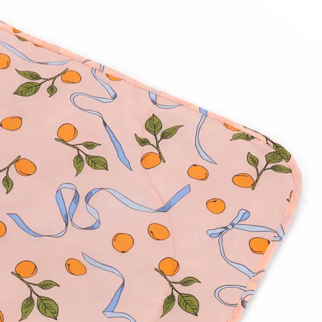 Baggu Puffy Picnic Blanket in Apricots and Ribbons print, detail of corner.