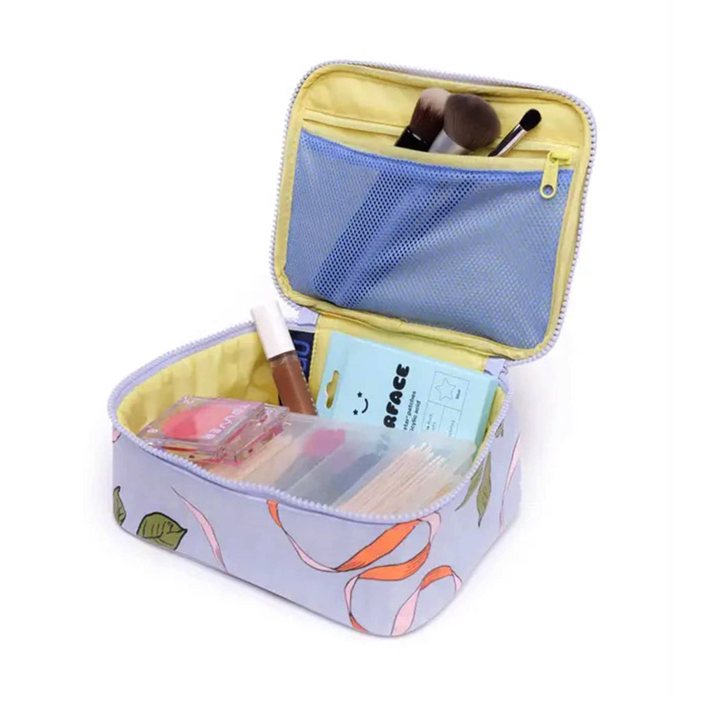 Baggu small cosmetic case with apricots and ribbons print, open with makeup inside.