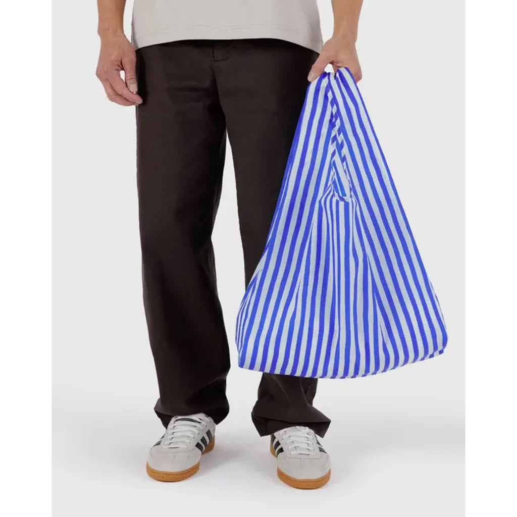 Baggu Blue Painted Stripe standard ripstop nylon reusable bag, in models hand.