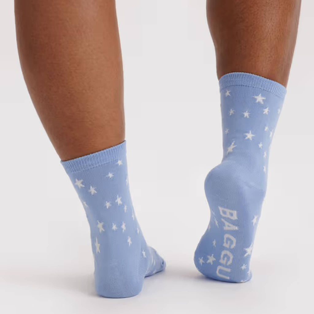 Light blue socks with star patterns worn by a person on a white background.