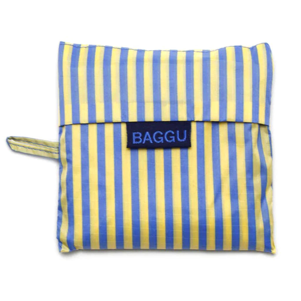 Baggu standard size eco-friendly recycled ripstop nylon reusable tote bag with yellow and blue thin stripe print, in matching pouch.