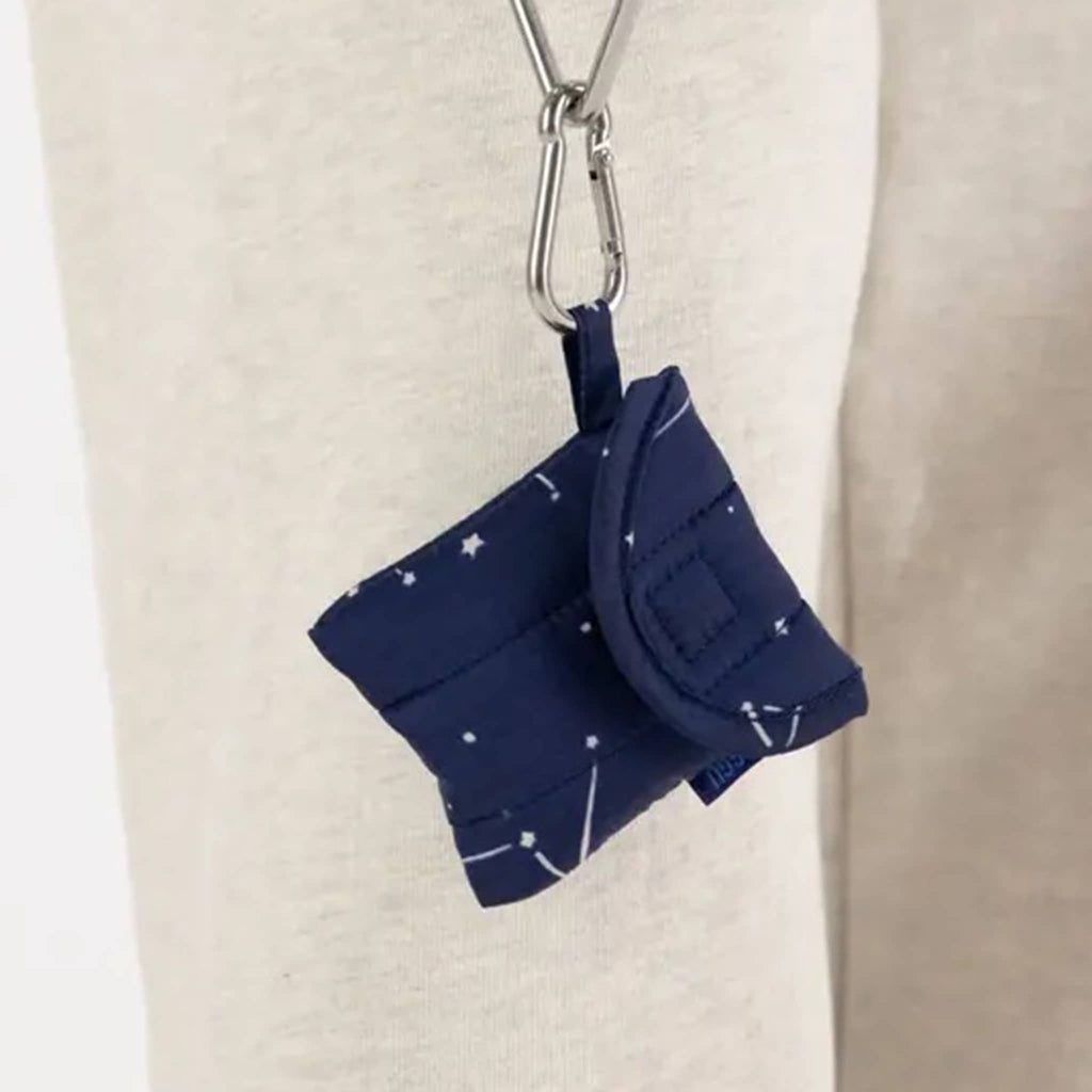 Baggu puffy earbuds case with constellation midnight print, hanging from metal carabiner.