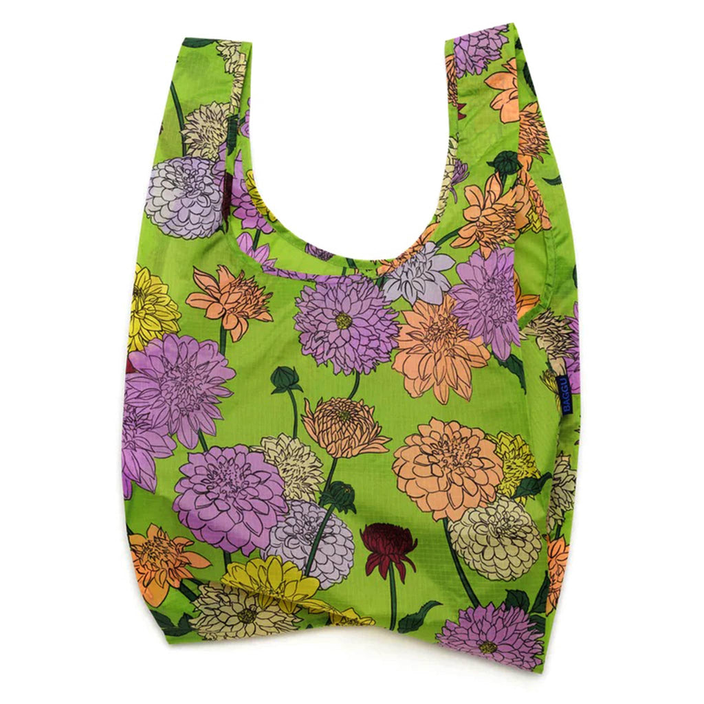 Baggu standard size eco-friendly recycled ripstop nylon reusable tote bag with a colorful dahlia print on a green backdrop, unfolded.