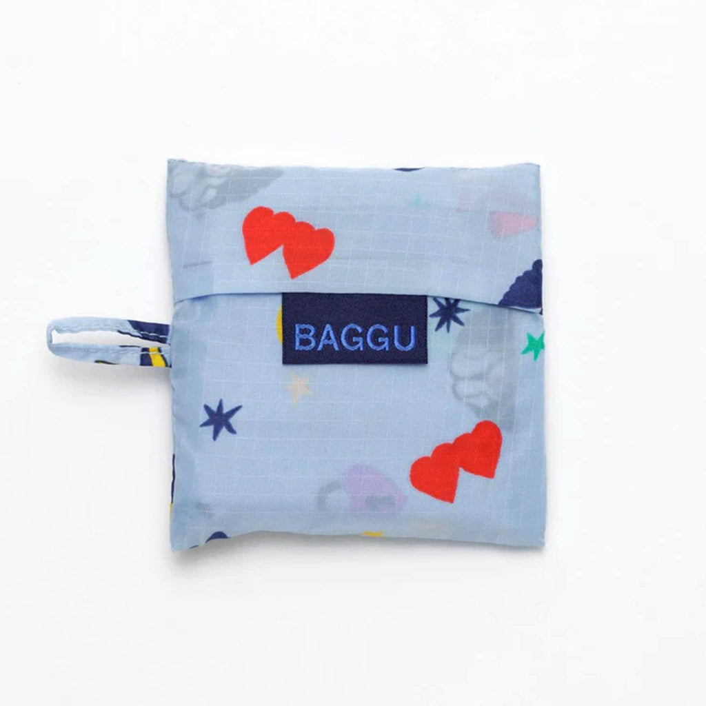 Baggu baby size eco-friendly recycled ripstop nylon reusable tote bag with Ditsy Charms print on a light blue background, in matching pouch.