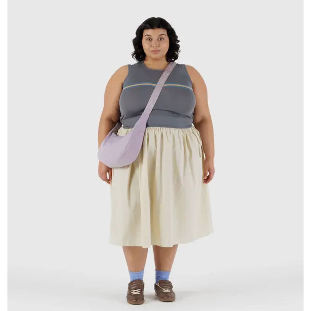 Baggu Medium Crescent Bag in Dusty Pink, with crossbody strap on model.