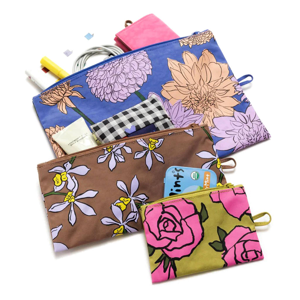 Baggu recycled ripstop nylon flat zipper pouches, set of 3 in assorted sizes with prints from the Garden Flowers collection, flat and unzipped with cords, sunscreen and office supplies coming out of the tops.