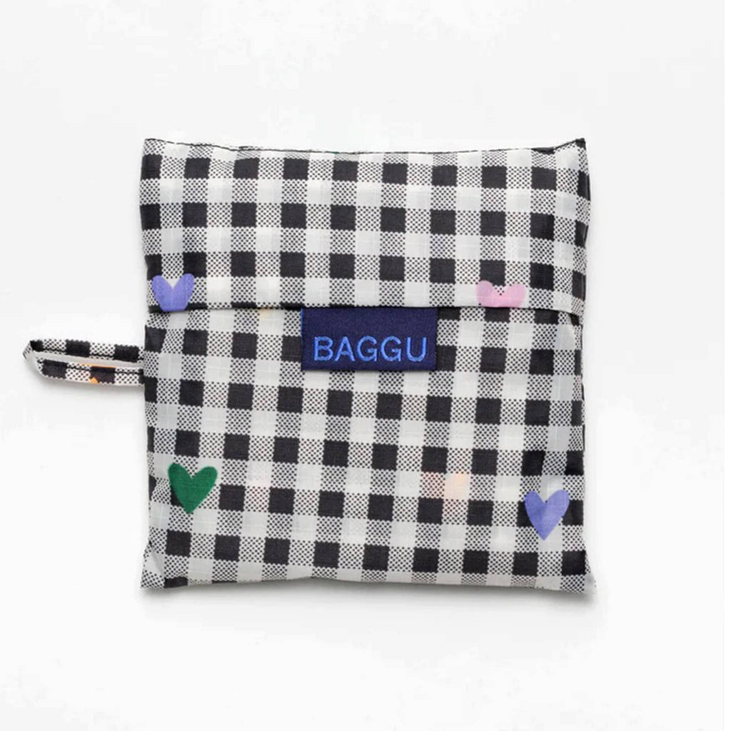Baggu standard size eco-friendly recycled ripstop nylon reusable tote bag with tiny colorful hearts on a black and white gingham backdrop, in matching pouch.