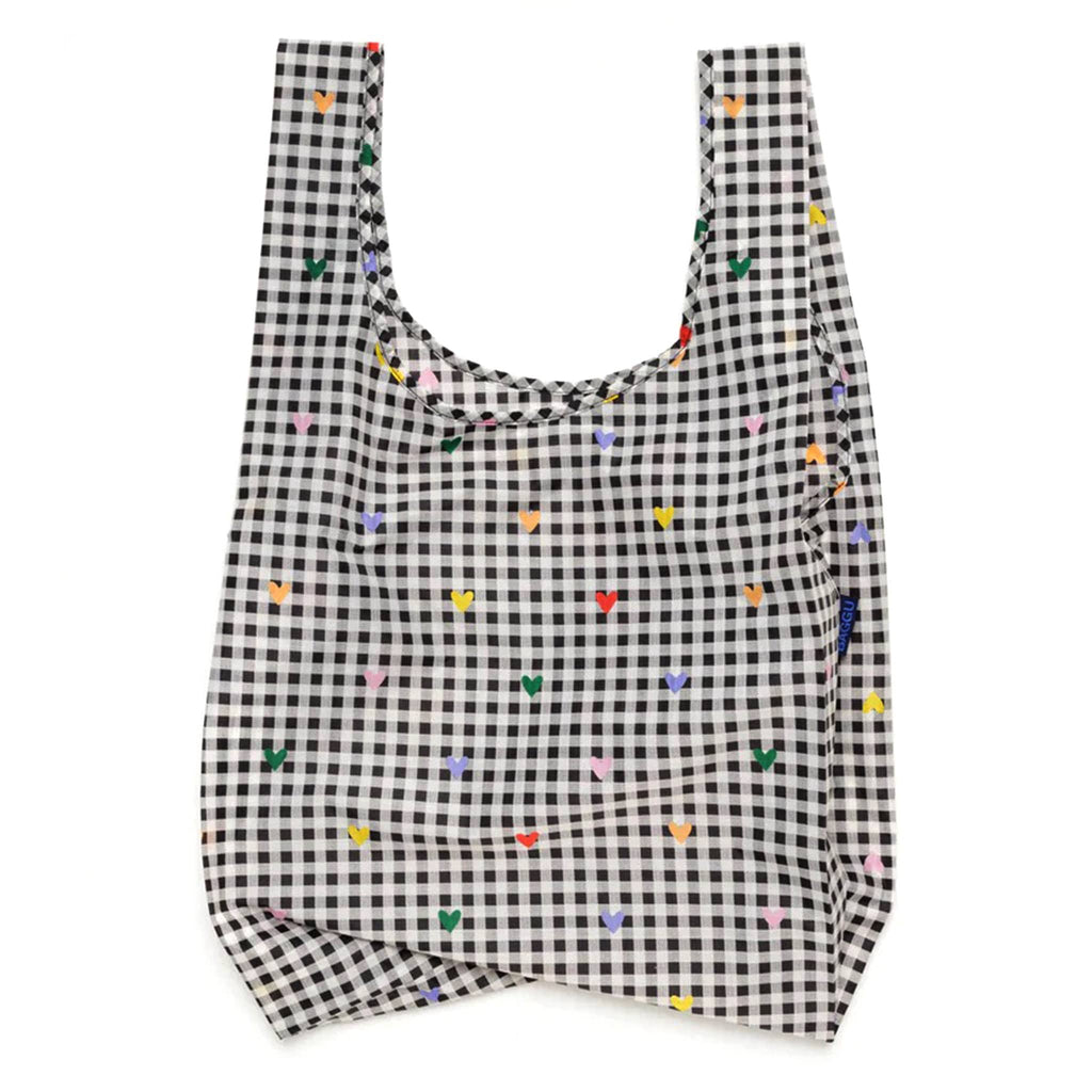 Baggu standard size eco-friendly recycled ripstop nylon reusable tote bag with tiny colorful hearts on a black and white gingham backdrop, unfolded.