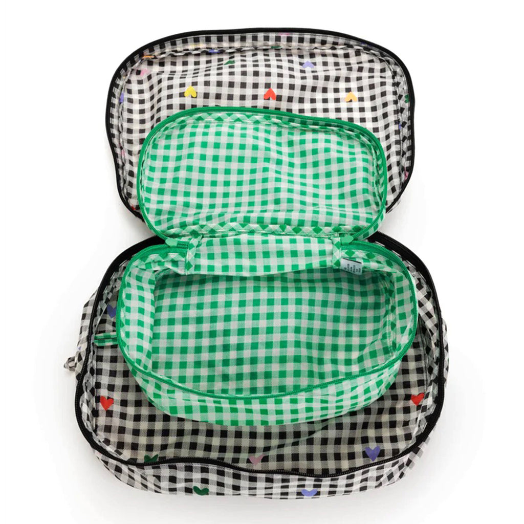 Baggu reusable recycled ripstop nylon packing cube set of 2, large is black and white gingham with colorful hearts and the small cube is green and white gingham print, unzipped and nested.